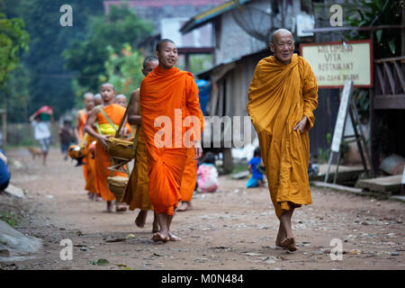 Mönche zu Fuß zurück zum Tempel nach dem Sammeln von Almosen am frühen Morgen in Muang Ngoi, nördlichen Laos Stockfoto