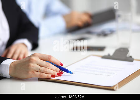 Junge Geschäftsfrau auf dem Schreibtisch mit Ordner Stockfoto