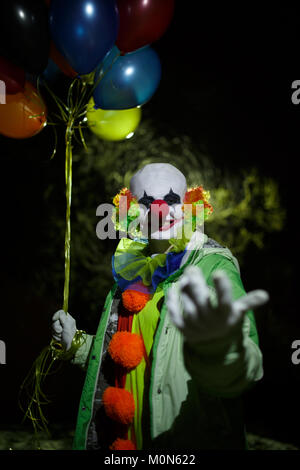 Fotos von lächelnden Clowns mit bunten Ballons in der Nacht im Straße Stockfoto