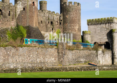 Arriva Zug passiert Conwy Castle von Robert Stephenson's tubular Rail Bridge. Conwy, Wales, Großbritannien, Großbritannien Stockfoto