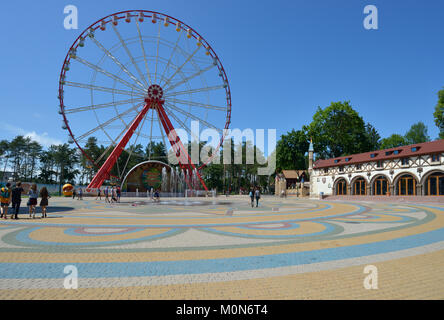 Kharkov, Ukraine - 10. Juni 2014: Leute, die sich vor dem Riesenrad im Central Park ruhenden benannt nach M.Gorki. Das Riesenrad ist 55 m hoch, Stockfoto