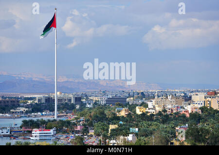 Aqaba, Jordanien - März 14, 2014: Die Fahne von Jordanien winkt über die Stadt. Aqaba hat eine der höchsten Wachstumsraten in Jordanien, mit nur 44 % Der buildin Stockfoto