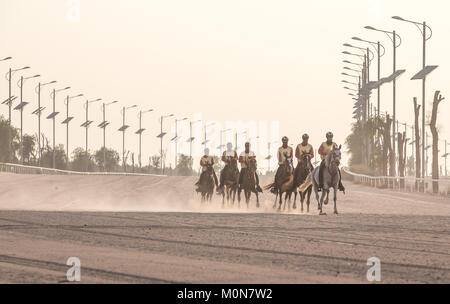 Sportliche Fahrer in einem Rennen konkurrieren in der Wüste bei Sonnenuntergang. Dubai, VAE. Stockfoto