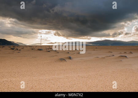 Dunkle nimbus Gewitterwolken bilden Sie eine Vorahnung Erscheinung am Himmel über ynyslas Mündung Strand. Sunlit Hintergrund aber eine dramatische, intensive Szene gefangengenommen Stockfoto