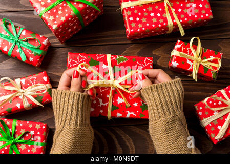 Frau verpacken Weihnachten über Holz- Tabelle vorhanden Stockfoto