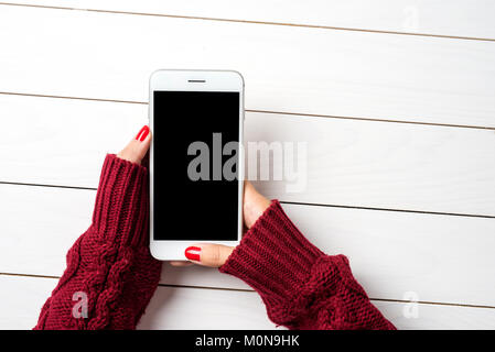 Frau mit einem Smartphone in warmen Pullover. Ansicht von oben Stockfoto
