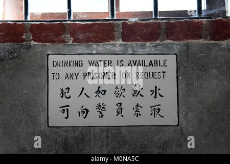 Indikationszeichen an der Wand in einem Gefängnis oder Gefängnis in englisch und chinesisch Stockfoto