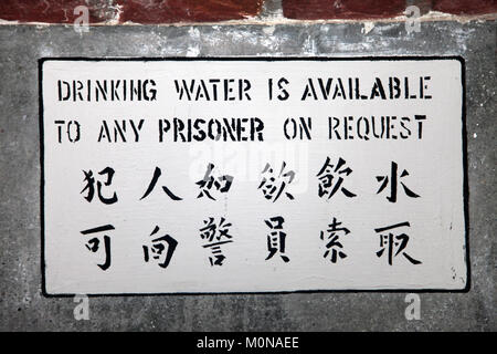 Indikationszeichen an der Wand in einem Gefängnis oder Gefängnis in englisch und chinesisch Stockfoto