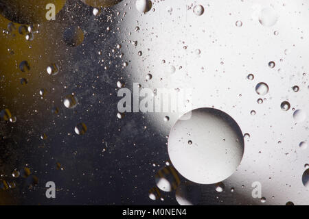 Öl Blasen im wässrigen Medium an der Grenze zu einer Glasoberfläche. Abstrakte Bildschirmschoner. Stockfoto