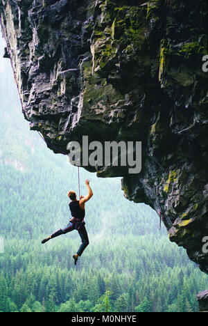 Mann aus einem Felsen klettern auf einem überhängenden Felsen, die North Fork des Snoqualmie, Washington, USA. Stockfoto