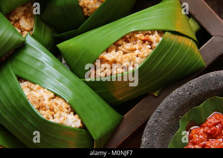 Nasi Tutug Oncom, der Sundanesischen Teller Reis mit fermentierten Sojabohnen; mit verschiedenen Beilagen serviert. Stockfoto