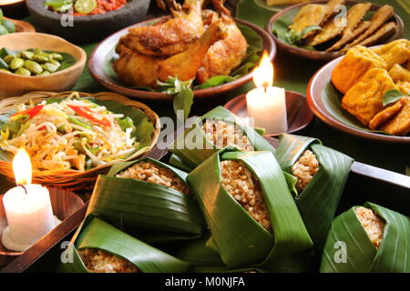 Nasi Tutug Oncom, der Sundanesischen Teller Reis mit fermentierten Sojabohnen; mit verschiedenen Beilagen serviert. Stockfoto