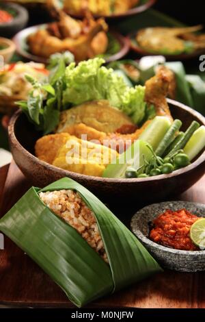 Nasi Tutug Oncom, der Sundanesischen Teller Reis mit fermentierten Sojabohnen; mit verschiedenen Beilagen serviert. Stockfoto