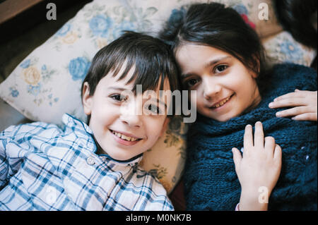 Portrait der Brüder im Schlafanzug zu Hause auf dem Boden liegend lächelnd Stockfoto