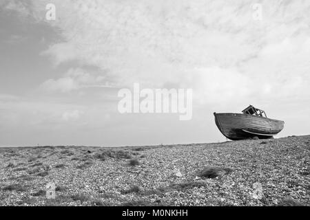 Alte zerstört Holz- shiplap Fischerboot auf Steinchen auf Dungeness Küste von Kent gewaschen. Alte havarierten Boot auf Buche Stockfoto