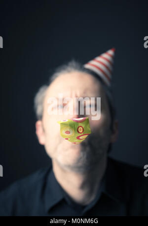 Karneval oder Geburtstag konzeptionelle Porträt eines Mannes auf einem dunklen Hintergrund Stockfoto