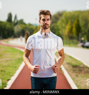 Junge Mann ist Joggen auf sonnigen Tag. Stockfoto