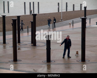 Leute, die an einem regnerischen Tag, indem er sich die goldene Spirale, in direkter Nähe zu den alten West Pier von Brighton Stockfoto