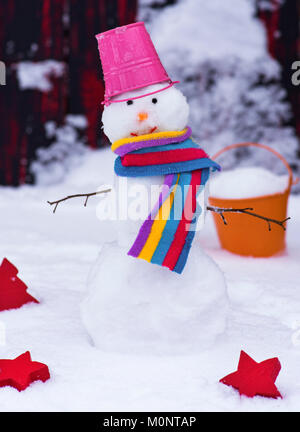 Schneemann mit einem Eimer auf dem Kopf auf weißem Schnee, ein Wintertag Stockfoto