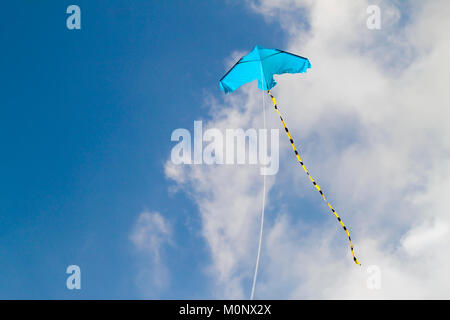 Drachen fliegen gegen den blauen Himmel an einem sonnigen Tag Stockfoto