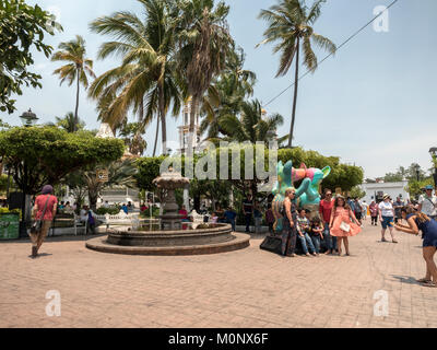 Eine Familie stellt mit der Statue des Colima tanzen Hunde (Xoloitzcuintle) Auf dem Hauptplatz von Comala Colima Mexiko Stockfoto