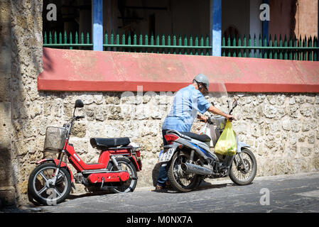 RHODES, Griechenland - AUGUST 2017: alte Mann ist der Motor von seinem Motorrad Stockfoto