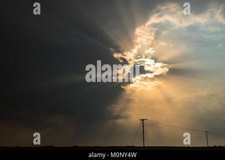 Durch den bewölkten Himmel verdunkelt, das Sonnenlicht Formen unglaubliche Wanderwege von Licht durch die Wolken Stockfoto