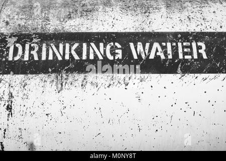 Ein schwarz-weiß Bild von einer Beschriftung Schild 'Drinking Water' an der Seite eines Wasser Tankwagen. Stockfoto