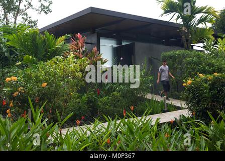 Costa Rica, Halbinsel Osa, Mitglied des Personals der Ecolodge Kura Design Villas, vor einem zeitgenössischen Design Suite mitten in einem tropischen Garten Stockfoto