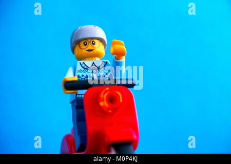 Tambow, Russische Föderation - Januar 13, 2018 Lego alte Frau Minifigur auf rotem scooter. Blauen Hintergrund. Studio gedreht. Stockfoto