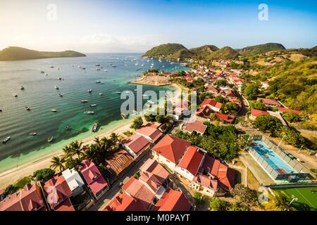 Frankreich, Karibik, Kleine Antillen, Guadeloupe, Les Saintes, Terre-de-Haut, Antenne Aussicht auf die Bucht der Stadt von Terre-de-Haut, die von der UNESCO zu den 10 schönsten Buchten der Welt eingestuft, Basse-Terre Hintergrund (Luftbild) Stockfoto
