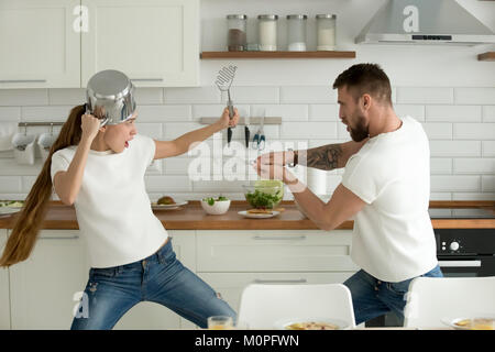 Lustig paar Spaß kämpfen mit Küchengeräte kochen t Stockfoto