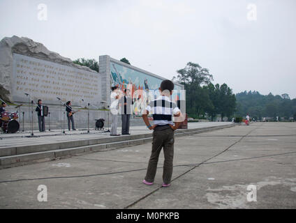 Nordkoreanische junge Abhören einer Band spielt Musik auf nationaler Tag auf der Straße, Pyongan Provinz, Pyongyang, Nordkorea Stockfoto