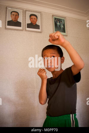 Nordkoreanische Kind taekwondo unter der Porträts von Kim Il Sung und Kim Jong Il, Süd-pyongan Provinz, Chonsam kooperative Farm, Nordkorea Stockfoto