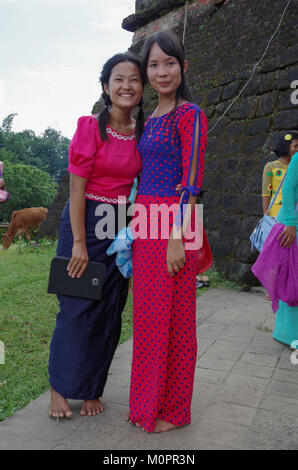 Porträt von zwei traditionell gekleidete, hübsche, junge Frauen vor einer alten Pagode in Mrauk U, Rakhine, Myanmar Stockfoto