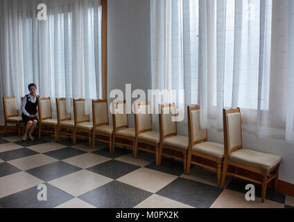 Nordkoreanische Kellnerin sitzen auf einem Stuhl in majon Beachfront holiday cottages Restaurant, Provinzen Süd-Hamgyong Provinz, Hamhung, Nordkorea Stockfoto