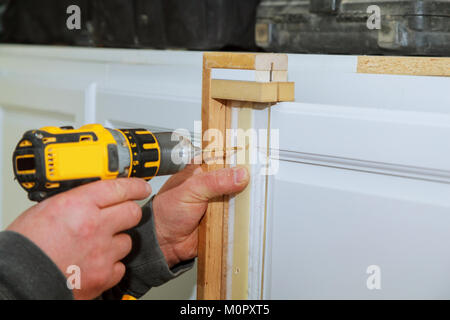 Installation von Möbel Scharniere an der Schranktür master Bohrer die Tür in der Schaltschranktür Stockfoto