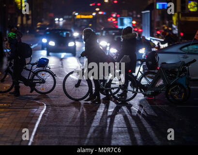 Schwerin, Deutschland. 24 Jan, 2018. Fußgänger und Radfahrer beim Überqueren einer Straße während des morgendlichen Berufsverkehrs in Schwerin, Deutschland, 24. Januar 2018. Credit: Jens Büttner/dpa-Zentralbild/dpa/Alamy leben Nachrichten Stockfoto