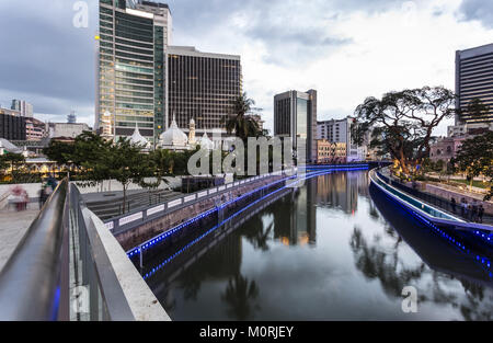 Büro gebäude spiegeln sich im Wasser des Klang Fluss vor dem Jamek Moschee (MASJID) im Herzen von Kuala Lumpur in Malaysia in der Nacht. Die Stockfoto