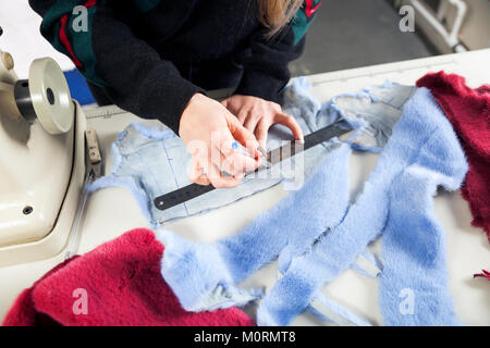 Der Prozess der Herstellung Pelzmantel einer Frau. Eine Nahaufnahme eines jungen Kürschner Frau malen ein blaues Fell hat für das Fell einer Frau Stockfoto