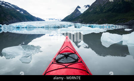 Ein rotes Kajak schwimmt unter vielen Eisberge aus der Spencer Gletscher in der Ferne Gekalbt. Nahezu perfekt ruhigen Wasser eines alpinen See in Alaska. Stockfoto