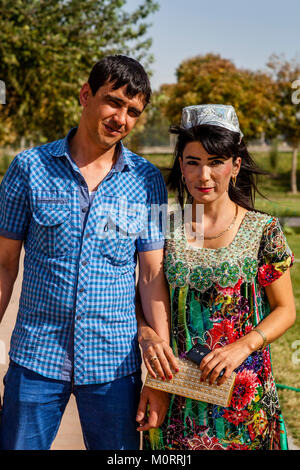 Eine junge USBEKISCHE Paar (Frau in traditioneller Tracht) Für ein Foto bei der Registan, Samarkand, Usbekistan dar Stockfoto