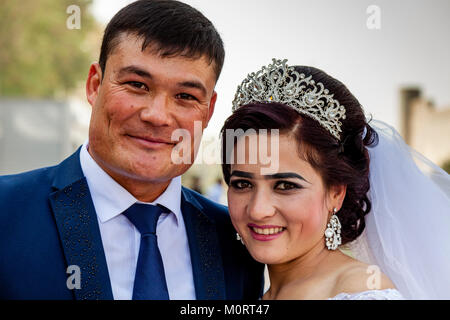 Eine 'Just Married' junge Paar posieren für Fotos Am Registan Komplexes, der Registan, Samarkand, Usbekistan Stockfoto