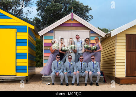 Hochzeit Party im baden Kästen auf der Dendy Street Beach an der Brighton posiert auf Port Phillip Bay, Melbourne, Australien Stockfoto