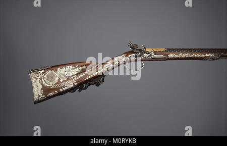 Dieses Set enthält ein Feuersteingewehr, ein Paar Pistolen und Zubehör, das feine Handwerkskunst und historische Bedeutung von Schusswaffen zeigt. Stockfoto