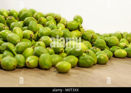 Viel Grün junge Walnüsse in Schalen auf hölzernen Tisch Stockfoto