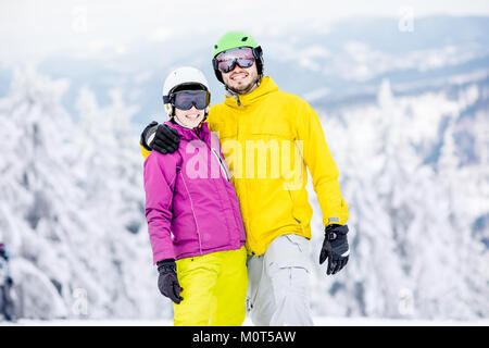 Paar in snowboarding Kleidung auf die verschneiten Berge Stockfoto