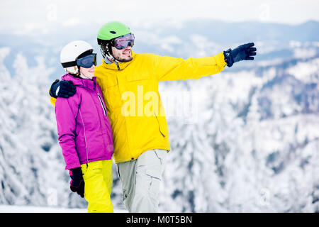 Paar in snowboarding Kleidung auf die verschneiten Berge Stockfoto