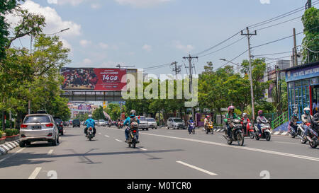 Mitte tag Verkehr auf einer der wichtigsten Straßen in Semarang, Indonesien. Es gibt weit mehr Motorräder und Scooter als Autos oder Trucks. Stockfoto