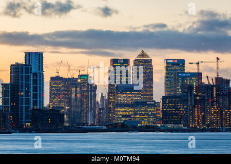 Die Türme von Canary Wharf in der Ferne mit der Themse im Vordergrund bei Sonnenuntergang, London, Vereinigtes Königreich, Januar 2018 Stockfoto